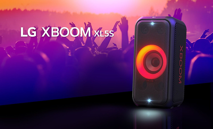 LG XBOOM XL5S trên sân khấu chiếu ánh sáng hòa trộn đỏ và cam. Sau sân khấu, mọi người đang tận hưởng âm nhạc.