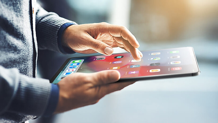 A man using the touchscreen on the iPad 12.9