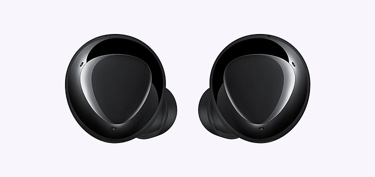 An enlarged pair of black earbuds displaying the triangular design on the outer surface.