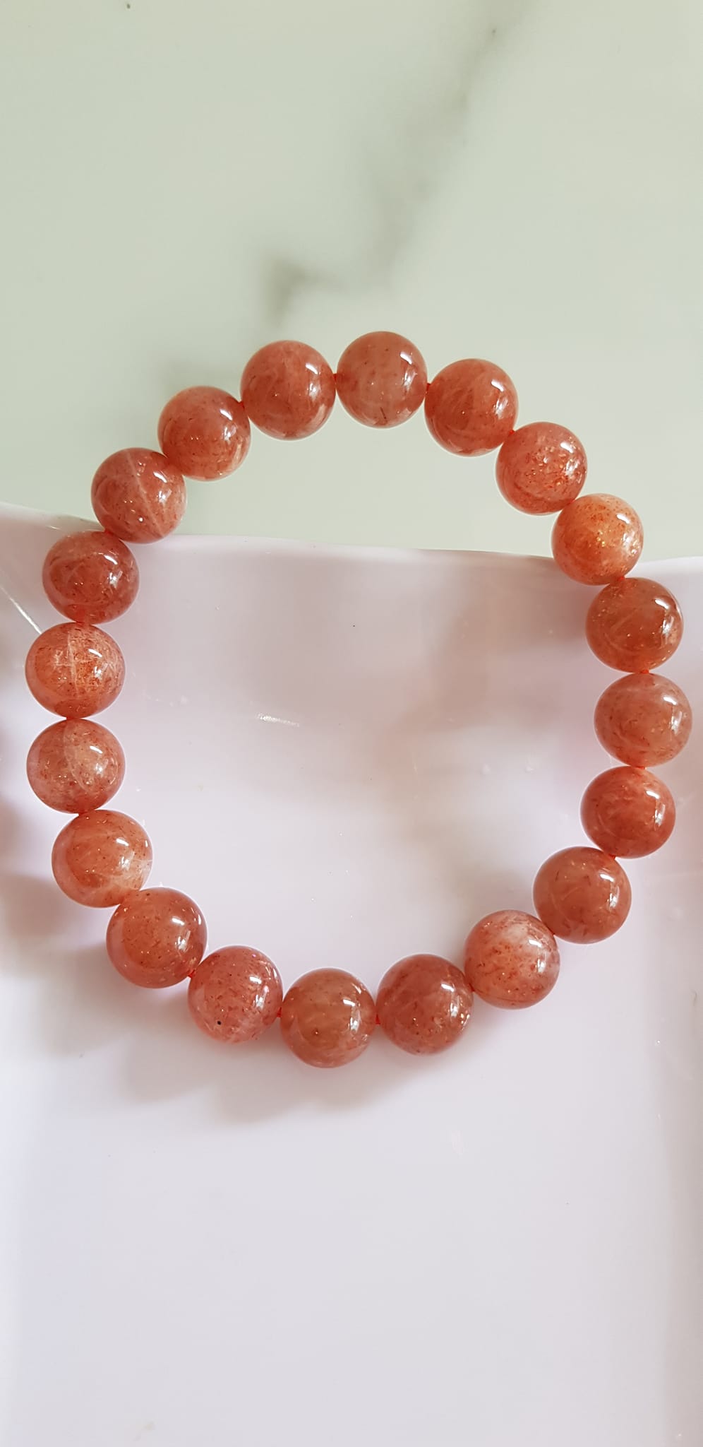 Vòng tay nữ đá mặt trời Sunstone Size 10li hay 10mm đẹp quyến rũ sang trọng đem lại sự tự tin Nổi bật bởi tông màu hồng cam nhẹ nhàng lấp lánh của đá mặt trời Sunstone tượng trưng cho thần mặt trời đẹp Đá Sunstone phù hợp với người mệnh Thổ và mệnh Hỏa ạ