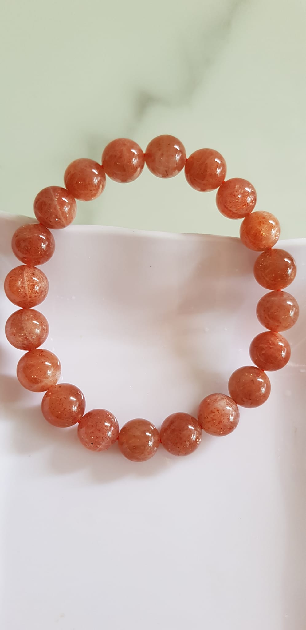 Vòng tay nữ đá mặt trời Sunstone Size 10li hay 10mm đẹp quyến rũ sang trọng đem lại sự tự tin Nổi bật bởi tông màu hồng cam nhẹ nhàng lấp lánh của đá mặt trời Sunstone tượng trưng cho thần mặt trời đẹp Đá Sunstone phù hợp với người mệnh Thổ và mệnh Hỏa ạ