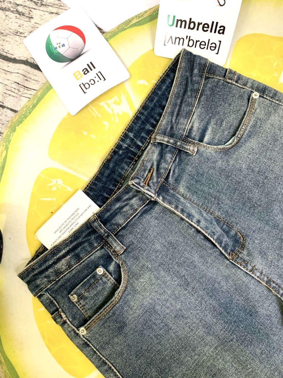 Quần jeans xanh bạc màu lai lật tua rua