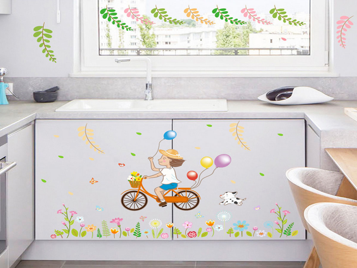 decal dán tường bé trai đạp xe cầm bóng bay sắc màu