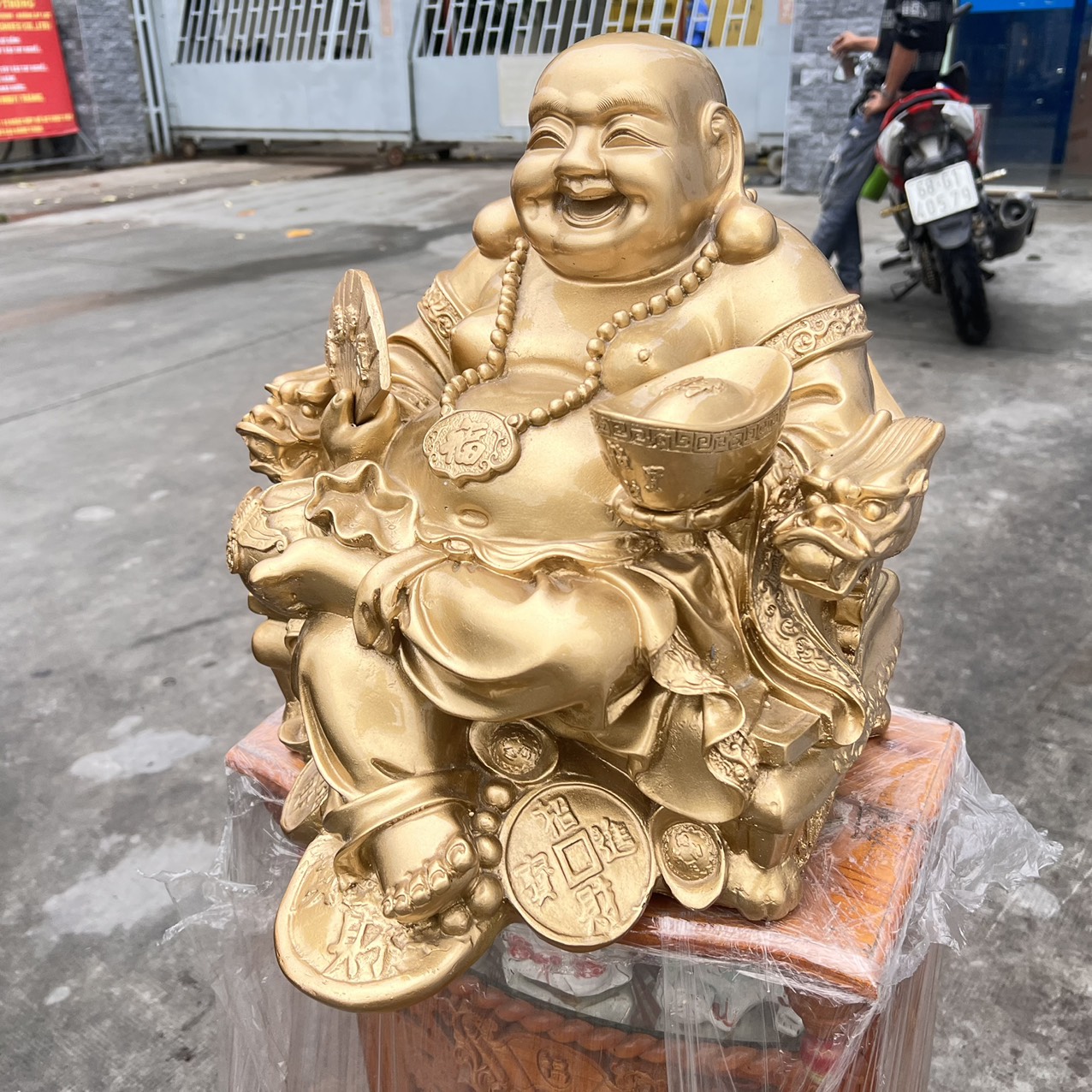 Tượng Di Lặc bột đá màu vàng đồng tay cầm quạt và thỏi vàng cao 37cm