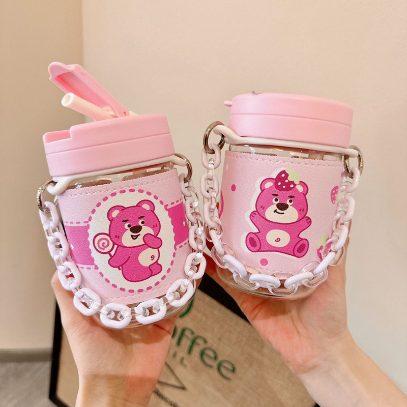 Bình nước gấu dâu có quai cầm kiểu dây xích cute - Bình nước thuỷ tinh có ống hút bọc da chống nóng hình gấu dâu Lotso