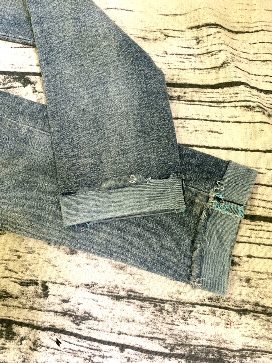 Quần jeans xanh bạc màu lai lật tua rua