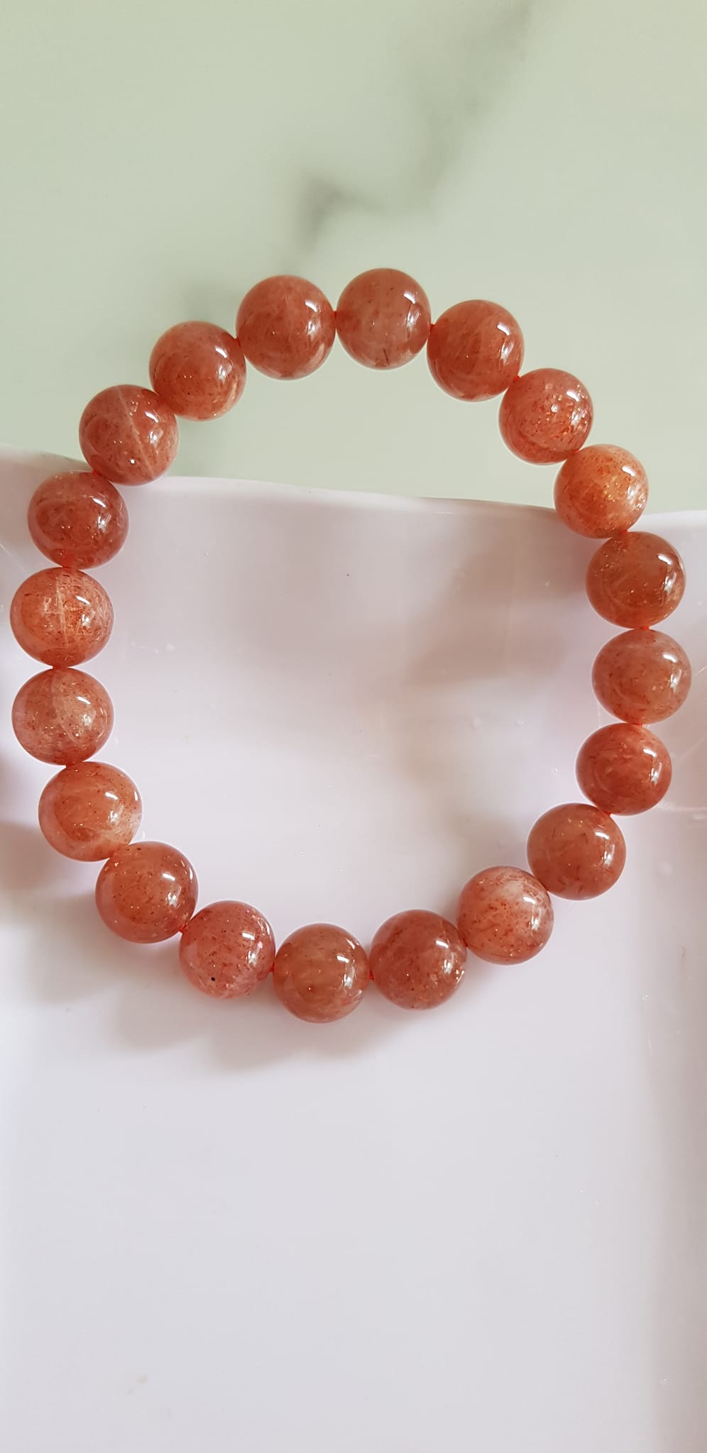 Vòng tay nữ đá mặt trời Sunstone Size 10li hay 10mm đẹp quyến rũ sang trọng đem lại sự tự tin Nổi bật bởi tông màu hồng cam nhẹ nhàng lấp lánh của đá mặt trời Sunstone tượng trưng cho thần mặt trời đẹp Đá Sunstone phù hợp với người mệnh Thổ và mệnh Hỏa ạ