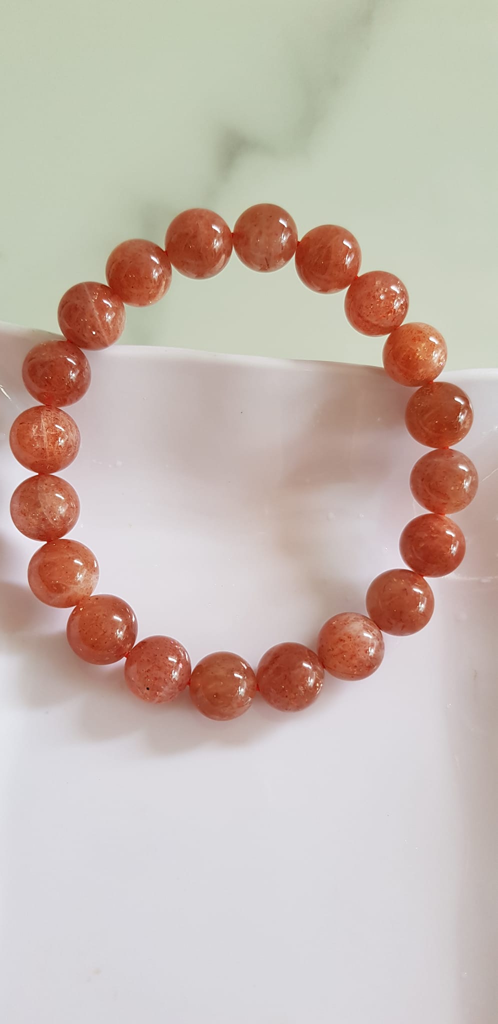 Vòng tay nữ đá mặt trời Sunstone Size 10li hay 10mm đẹp quyến rũ sang trọng đem lại sự tự tin Nổi bật bởi tông màu hồng cam nhẹ nhàng lấp lánh của đá mặt trời Sunstone tượng trưng cho thần mặt trời đẹp Đá Sunstone phù hợp với người mệnh Thổ và mệnh Hỏa ạ