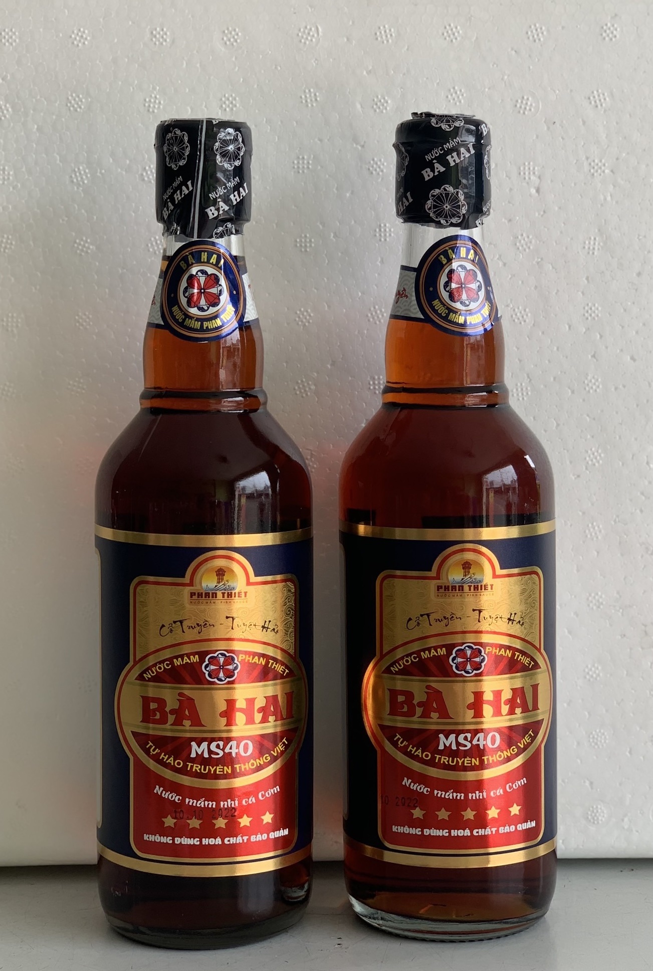 Xách 2 Chai Nước Mắm Nhĩ Cá Cơm Bà Hai