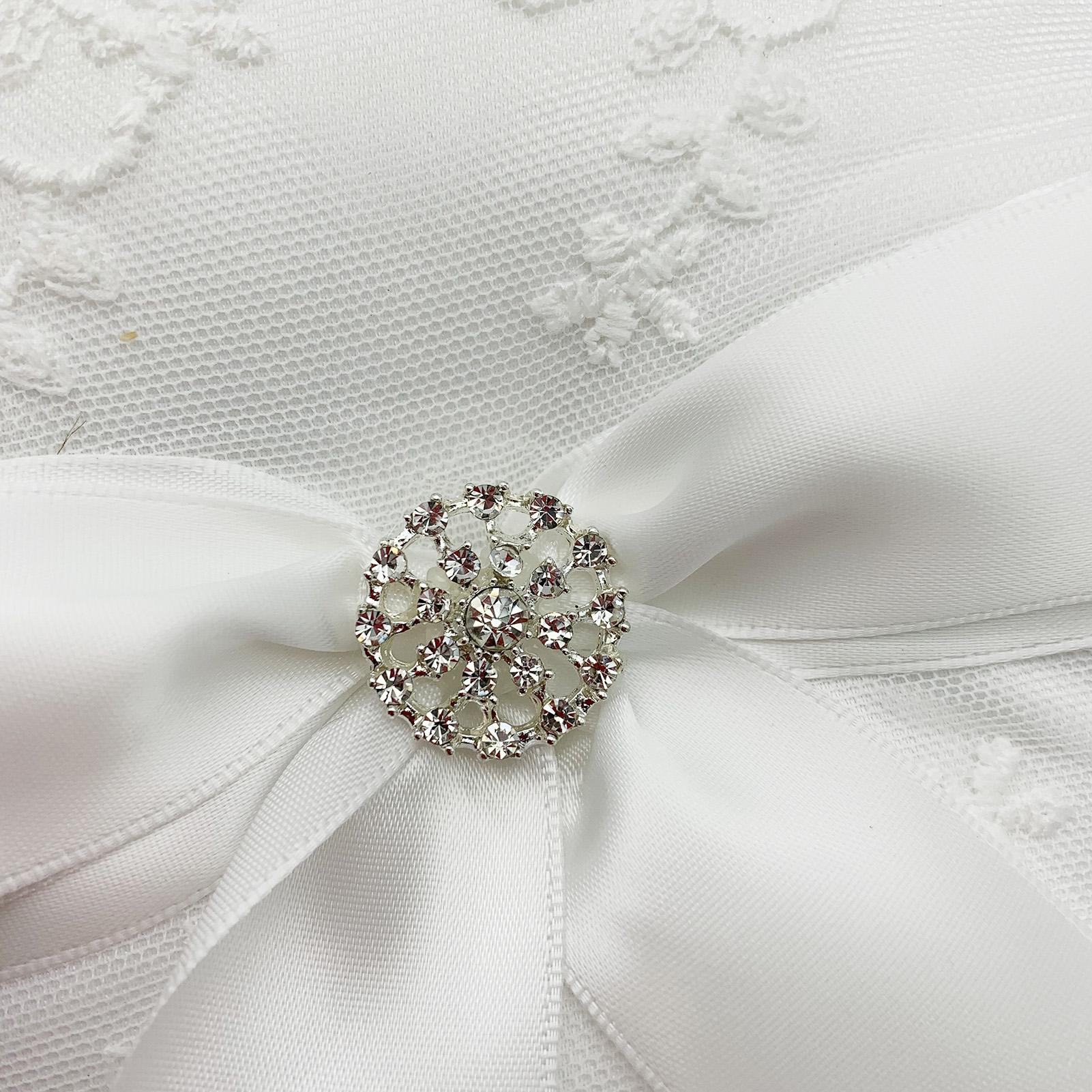 Gối nhẫn cưới mang vòng sa tanh trắng với nơ ruy băng, trang trí pha lê và ren