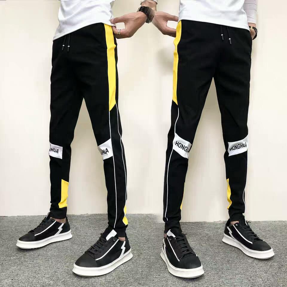 Quần Jogger nam nửa đường viền vàng bên hông , đầu gối có chữ in đơn giản đầy năng động