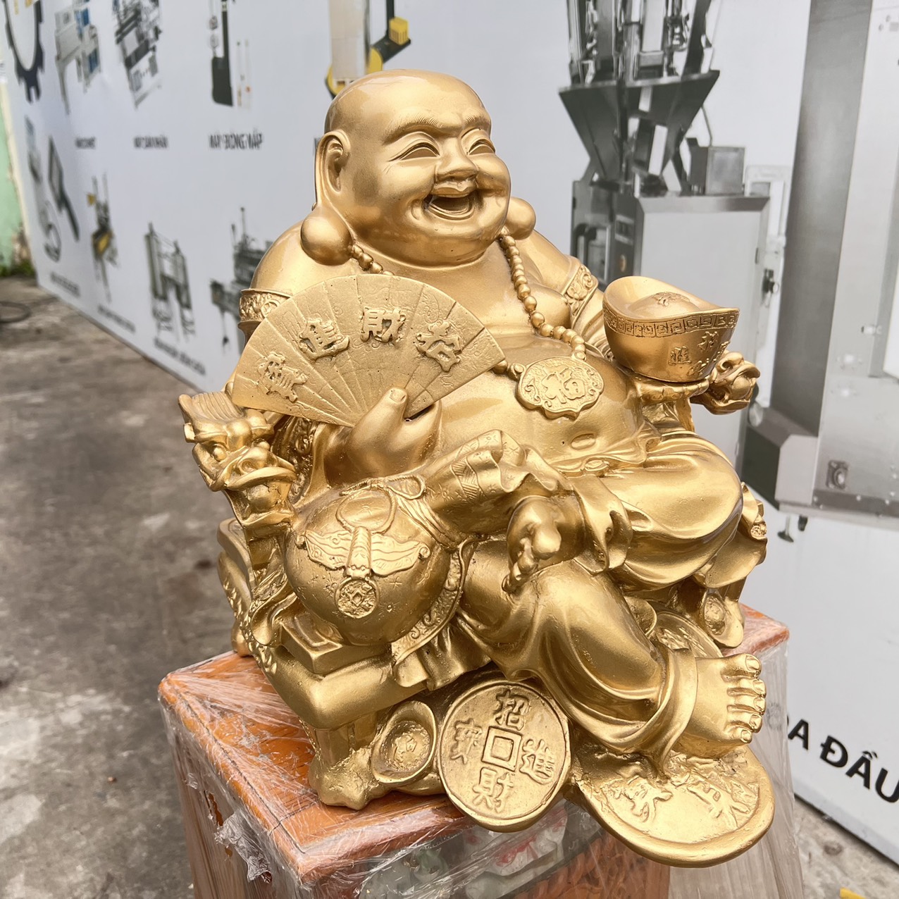 Tượng Di Lặc bột đá màu vàng đồng tay cầm quạt và thỏi vàng cao 37cm