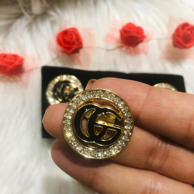 Cài áo tròn phối logo đính đá. KT 2,5 x 2,5cm