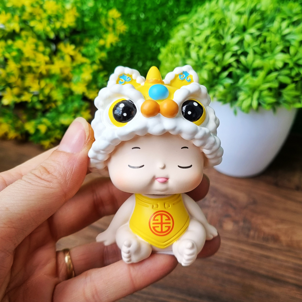Tượng em bé đội nón đầu Lân lò xo dễ thương màu vàng