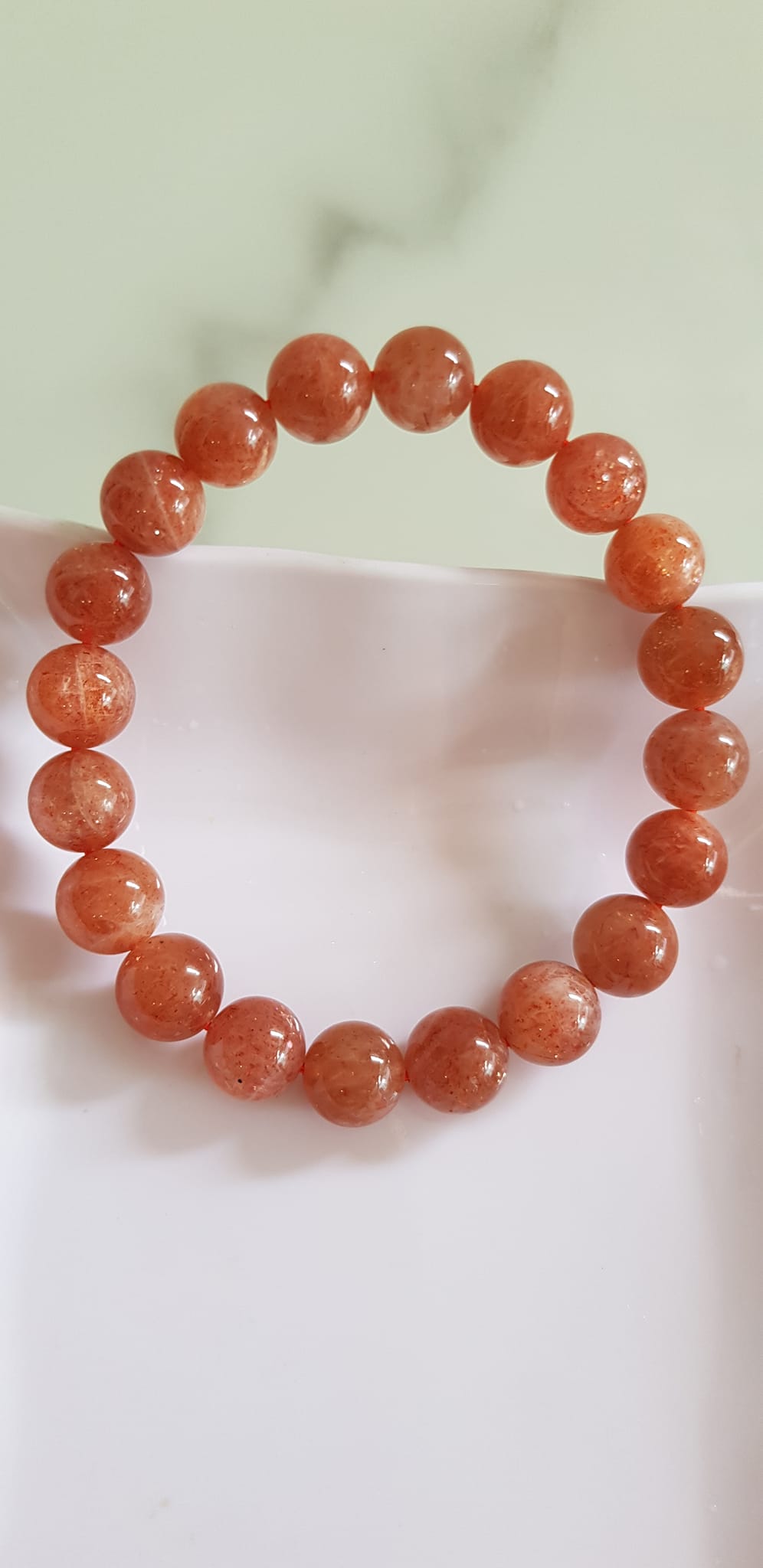 Vòng tay nữ đá mặt trời Sunstone Size 10li hay 10mm đẹp quyến rũ sang trọng đem lại sự tự tin Nổi bật bởi tông màu hồng cam nhẹ nhàng lấp lánh của đá mặt trời Sunstone tượng trưng cho thần mặt trời đẹp Đá Sunstone phù hợp với người mệnh Thổ và mệnh Hỏa ạ