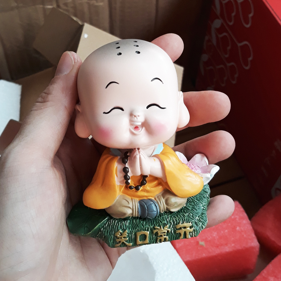 Tượng chibi chú tiểu tươi cười bên hoa sen