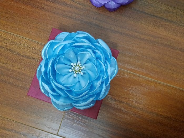 Bông hoa cài áo màu xanh, chất liệu mềm mịn