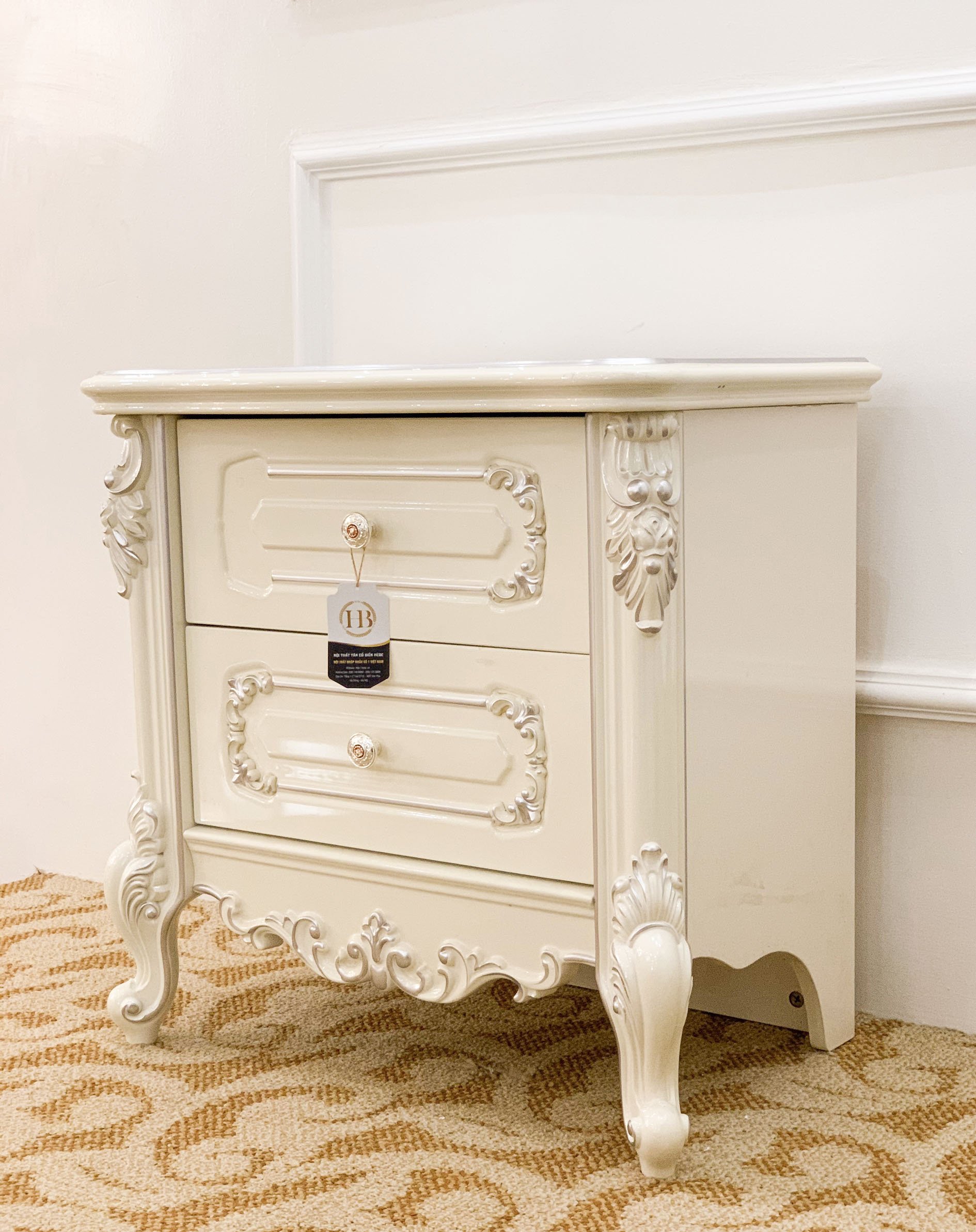 Táp đầu giường vuông được làm từ chất liệu gỗ sồi mỹ kết hợp với MDF vẽ chỉ bạc điểm nổi bật lên các họa tiết mang phong cách tân cổ điển và sang trọng