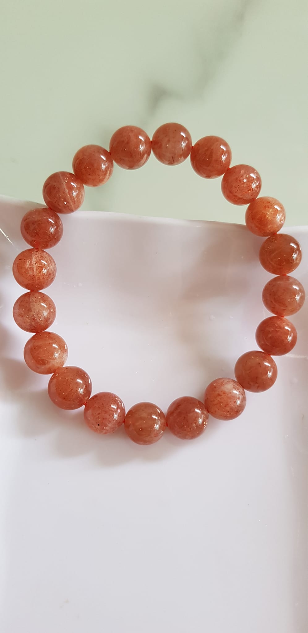 Vòng tay nữ đá mặt trời Sunstone Size 10li hay 10mm đẹp quyến rũ sang trọng đem lại sự tự tin Nổi bật bởi tông màu hồng cam nhẹ nhàng lấp lánh của đá mặt trời Sunstone tượng trưng cho thần mặt trời đẹp Đá Sunstone phù hợp với người mệnh Thổ và mệnh Hỏa ạ