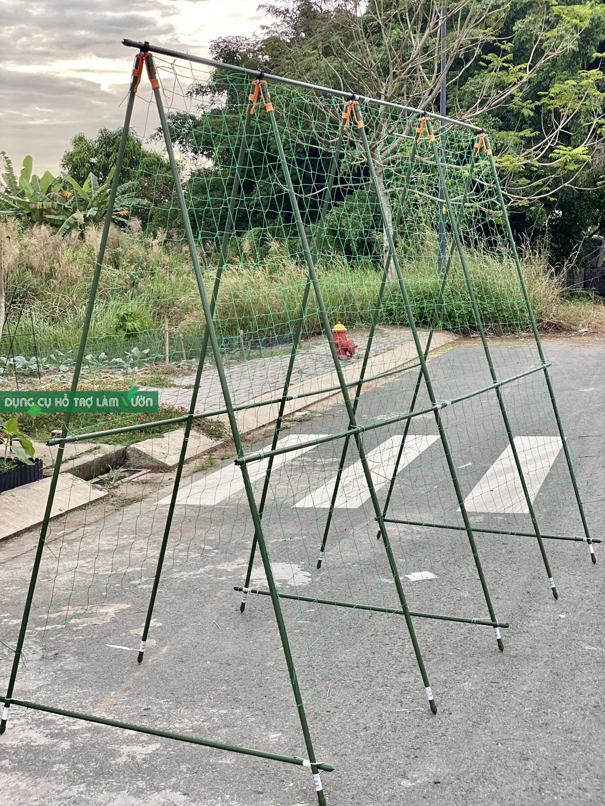 Giàn chữ A cao 2.1met dài 3 met ống phi 16 tự đứng trên nền gạch của Nhật chuyên dùng trồng các loại cây leo như bầu, bí mướp, khổ qua, dưa lưới 