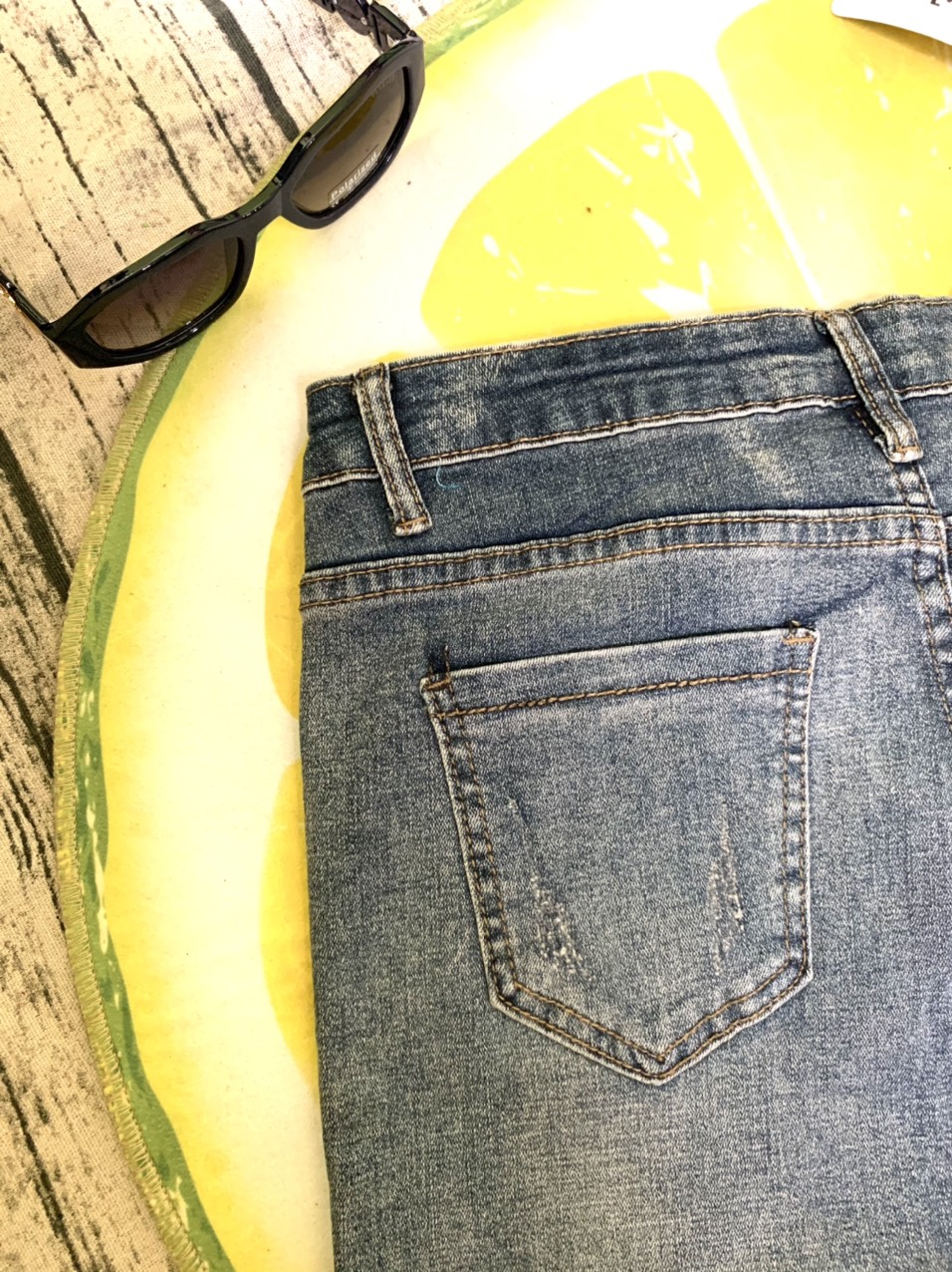 Quần jeans xanh bạc màu lai lật tua rua