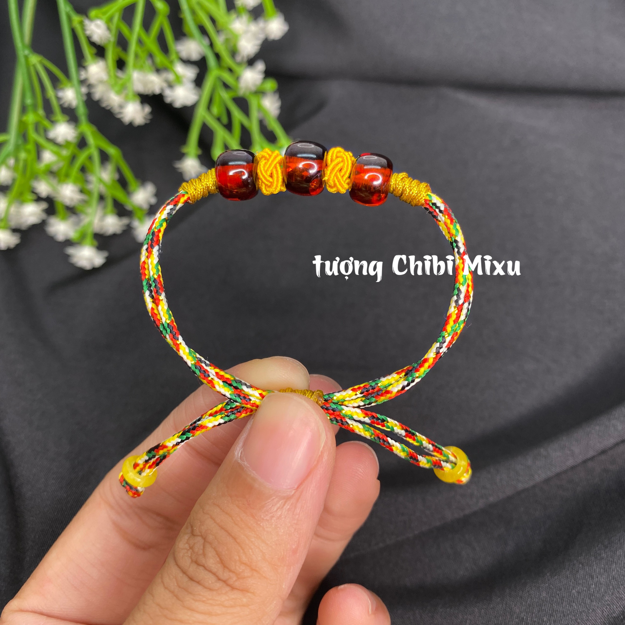 Vòng tay hổ phách màu đỏ nâu tết dây ngũ sắc cho bé