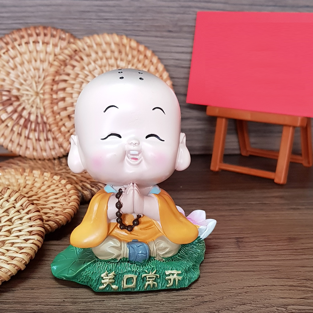 Tượng chibi chú tiểu tươi cười bên hoa sen