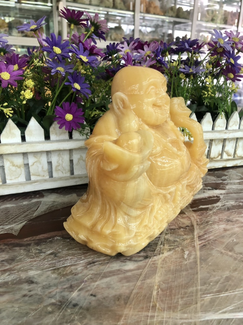 Hình ảnh Tượng Phật Di Lặc ngồi cầm thỏi vàng và gậy như ý phong thủy đá ngọc hoàng long - Dài 20 cm