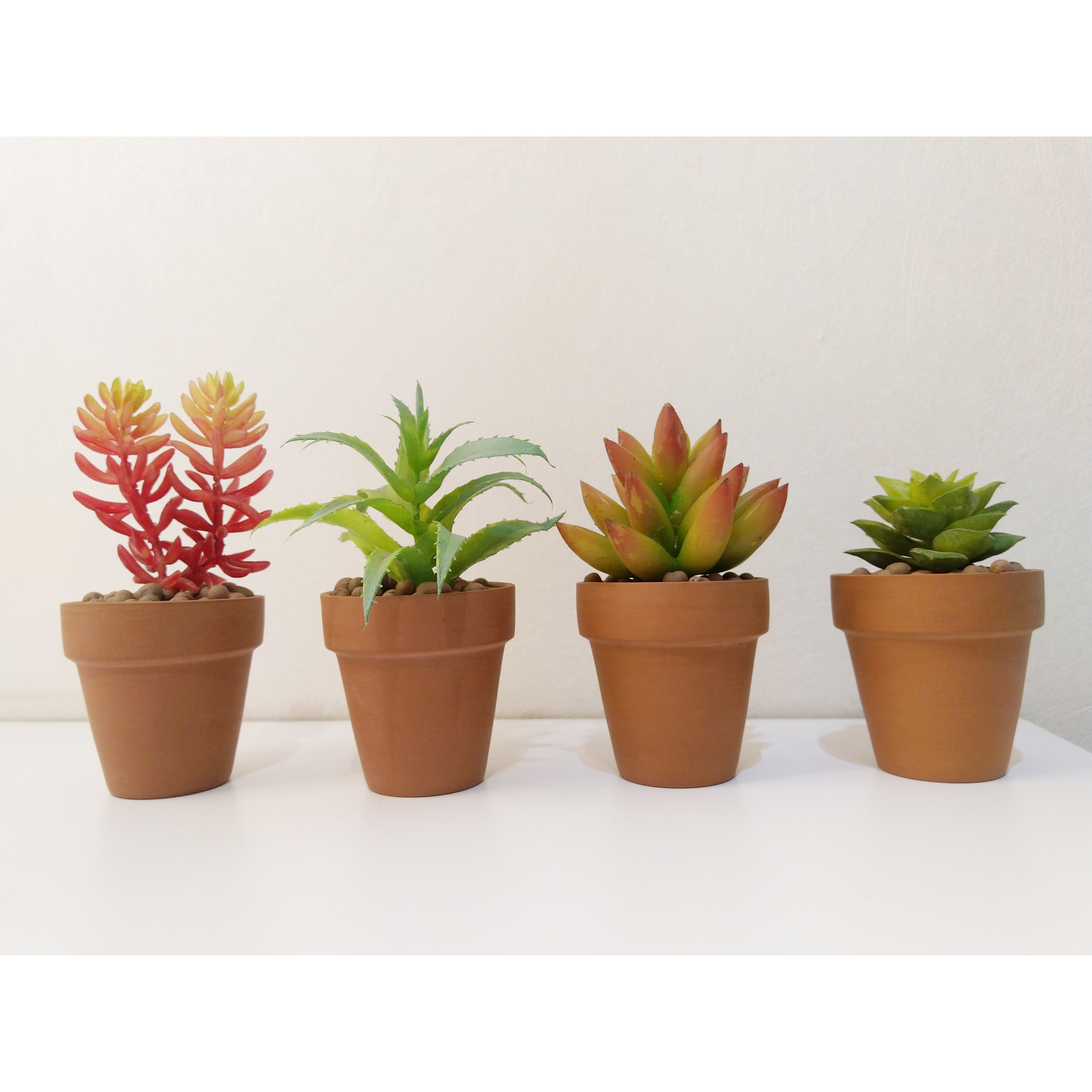Mang gạch đất nung ấm áp, mộc mạc vào phòng khách với  Bộ 4 chậu sen đá - xương rồng nhân tạo mini trang trí nhà cửa.