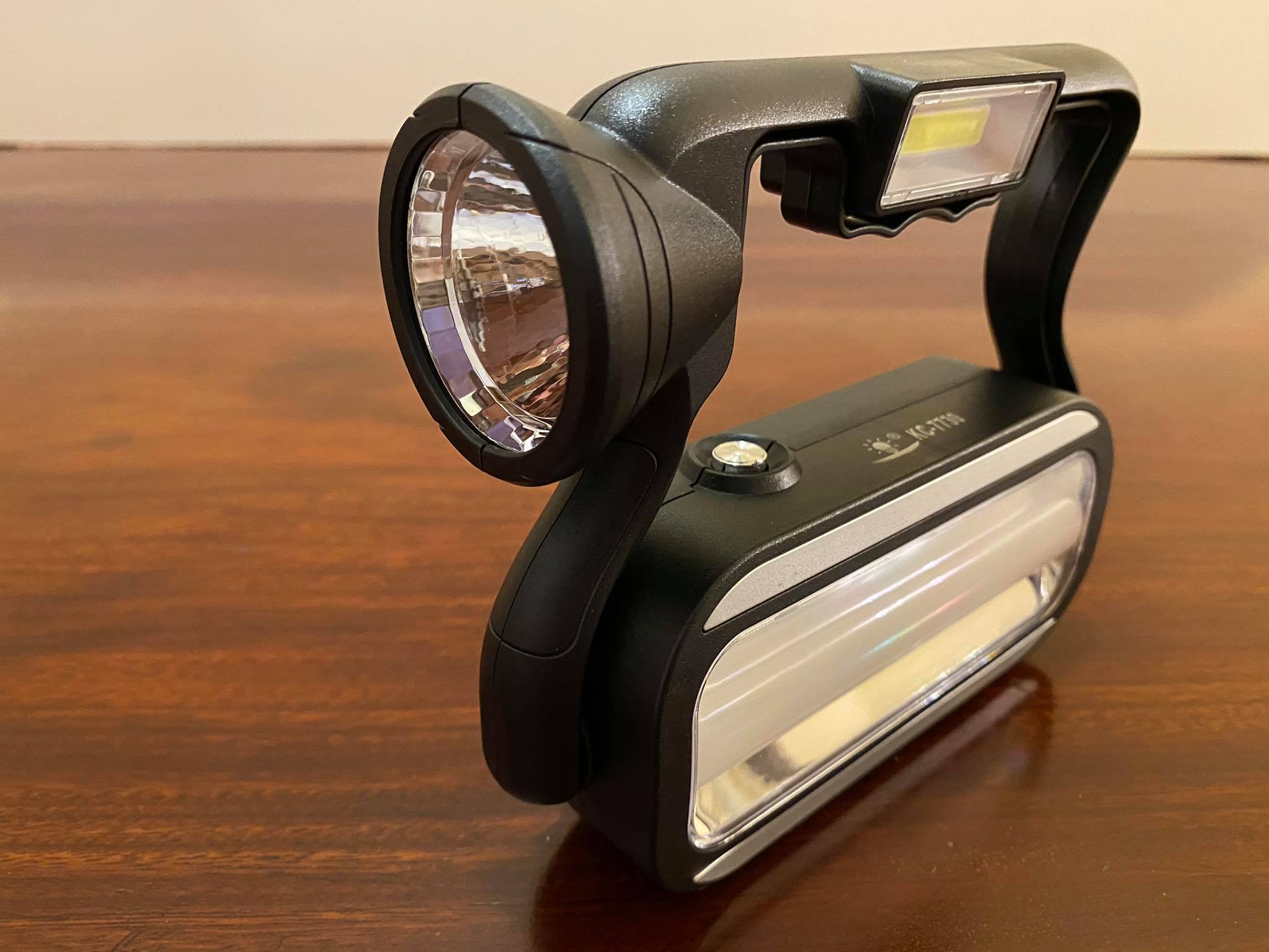 Đèn pin sạc xách tay 4 in 1 (đèn pin, đèn dự phòng cúp điện, đèn rọi xa, sạc khẩn cấp cho điện thoại), có thể sạc bằng điện hoặc sạc bằng năng lượng mặt trời, có móc treo tiện lợi