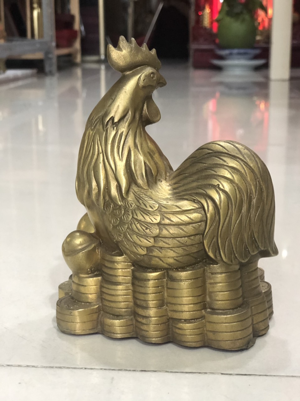 Tượng gà bằng đồng nằm trên tiền
