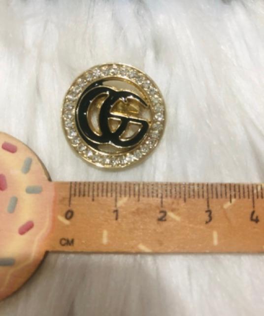 Cài áo tròn phối logo đính đá. KT 2,5 x 2,5cm