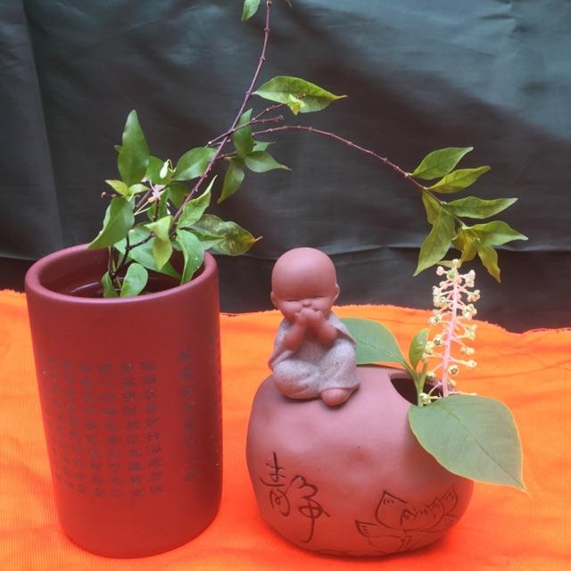 Chú tiểu ngồi trên tảng đá có thể cắm hoa , cắm bút