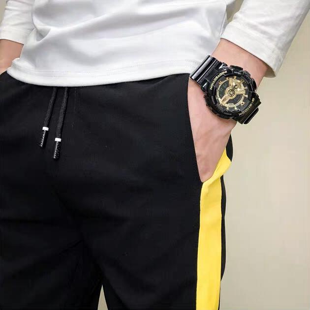 Quần Jogger nam nửa đường viền vàng bên hông , đầu gối có chữ in đơn giản đầy năng động