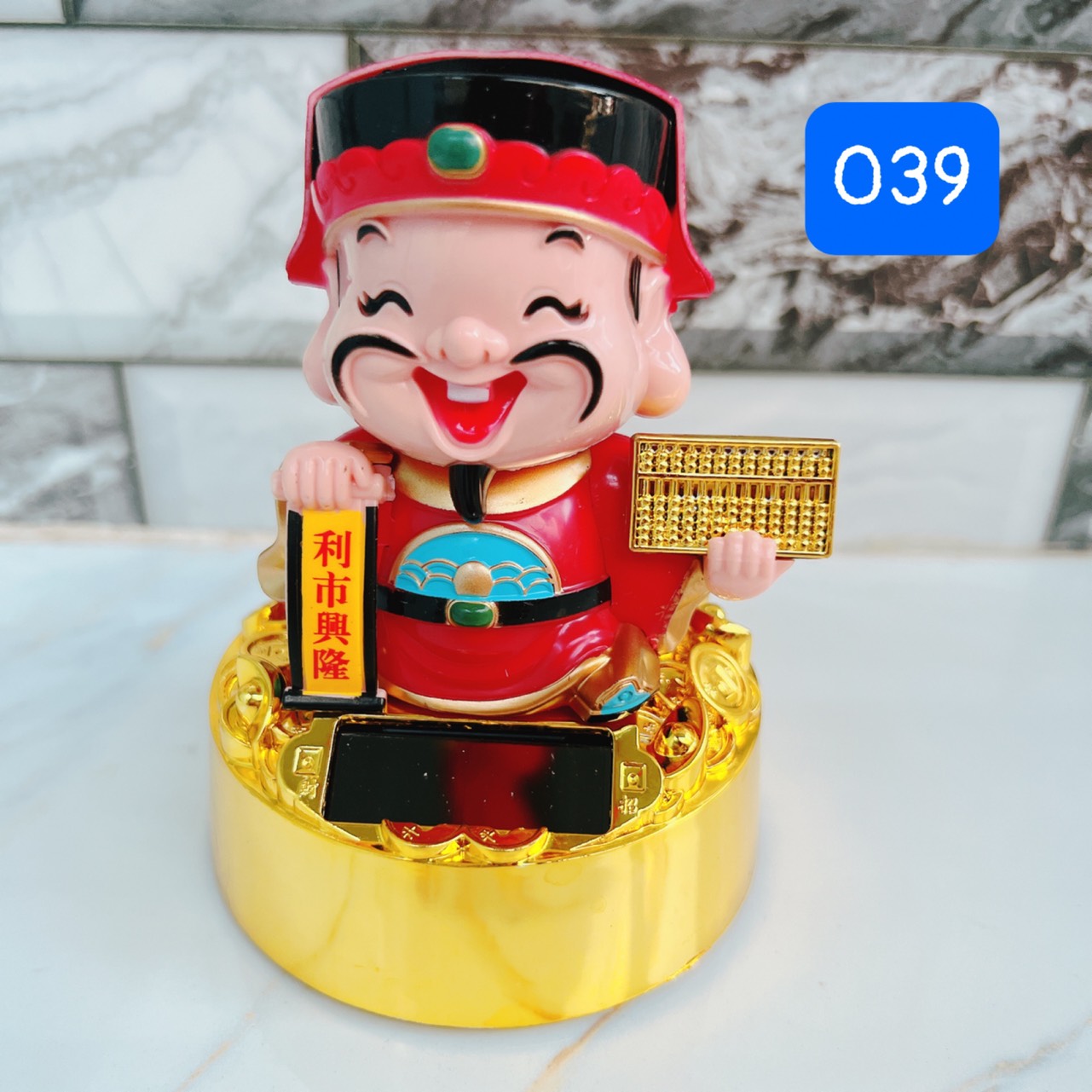 Thần tài áo đỏ ngồi trên đế tròn phong thủy mang lại may mắn cho mọi nhà, gật đầu sử dụng năng lượng mặt trời cao 11 cm