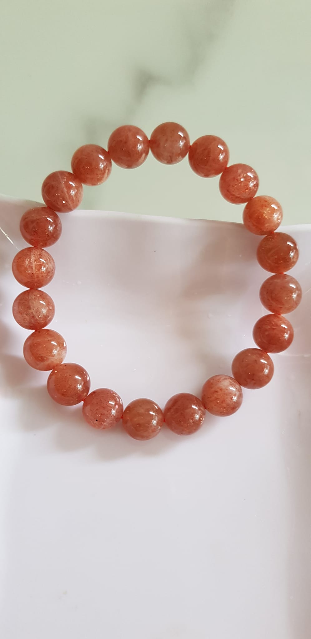 Vòng tay nữ đá mặt trời Sunstone Size 10li hay 10mm đẹp quyến rũ sang trọng đem lại sự tự tin Nổi bật bởi tông màu hồng cam nhẹ nhàng lấp lánh của đá mặt trời Sunstone tượng trưng cho thần mặt trời đẹp Đá Sunstone phù hợp với người mệnh Thổ và mệnh Hỏa ạ