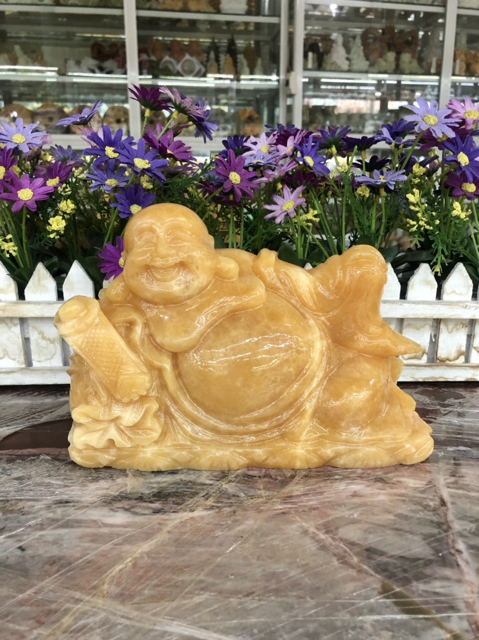 Hình ảnh Tượng Phật Di Lặc ngồi tựa bao tiền cầm gậy như ý phong thủy đá ngọc hoàng long - Dài 20 cm