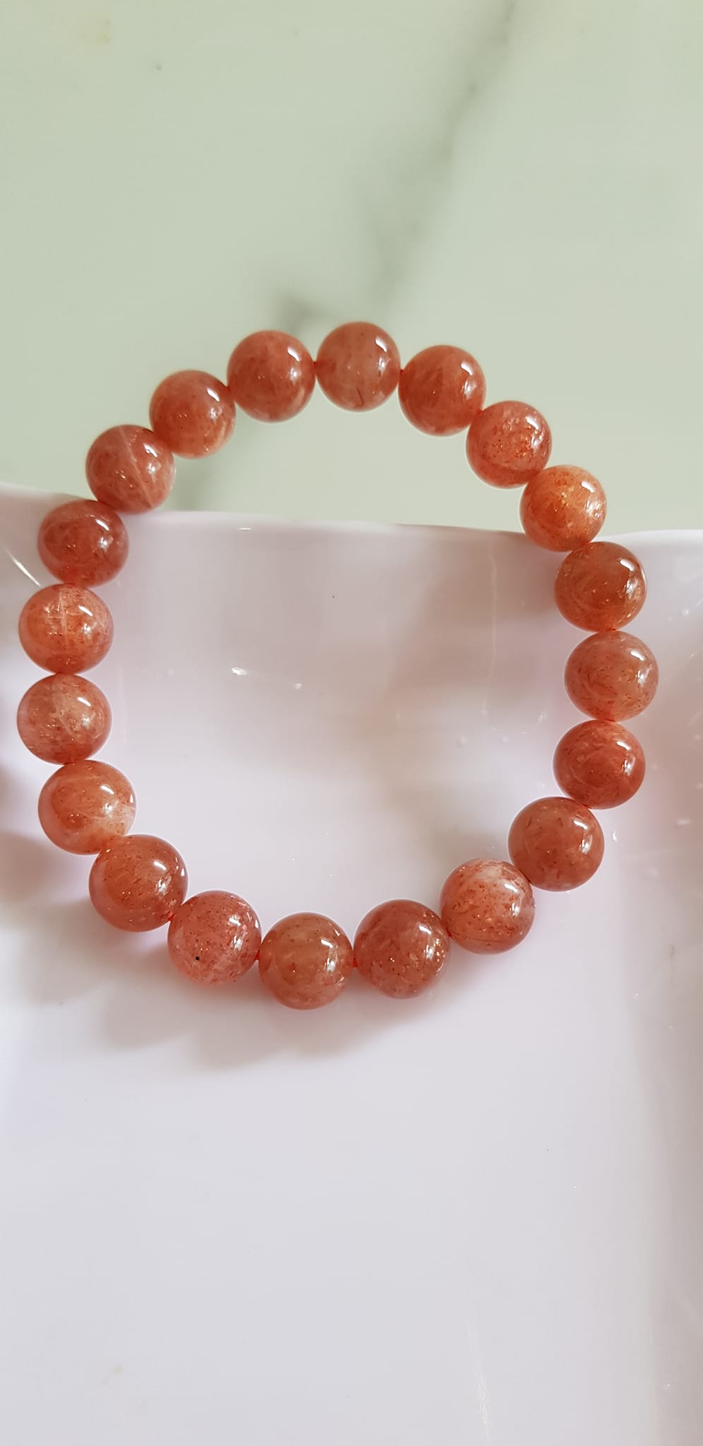 Vòng tay nữ đá mặt trời Sunstone Size 10li hay 10mm đẹp quyến rũ sang trọng đem lại sự tự tin Nổi bật bởi tông màu hồng cam nhẹ nhàng lấp lánh của đá mặt trời Sunstone tượng trưng cho thần mặt trời đẹp Đá Sunstone phù hợp với người mệnh Thổ và mệnh Hỏa ạ