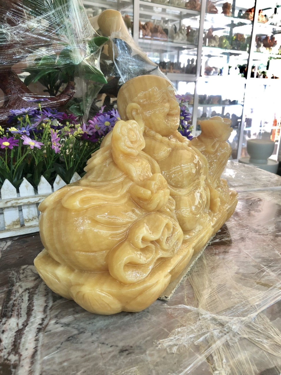 Hình ảnh Tượng Phật Di Lặc ngồi tựa bao tiền cầm thỏi vàng và gậy như ý phong thủy đá ngọc hoàng long - Dài 40 cm