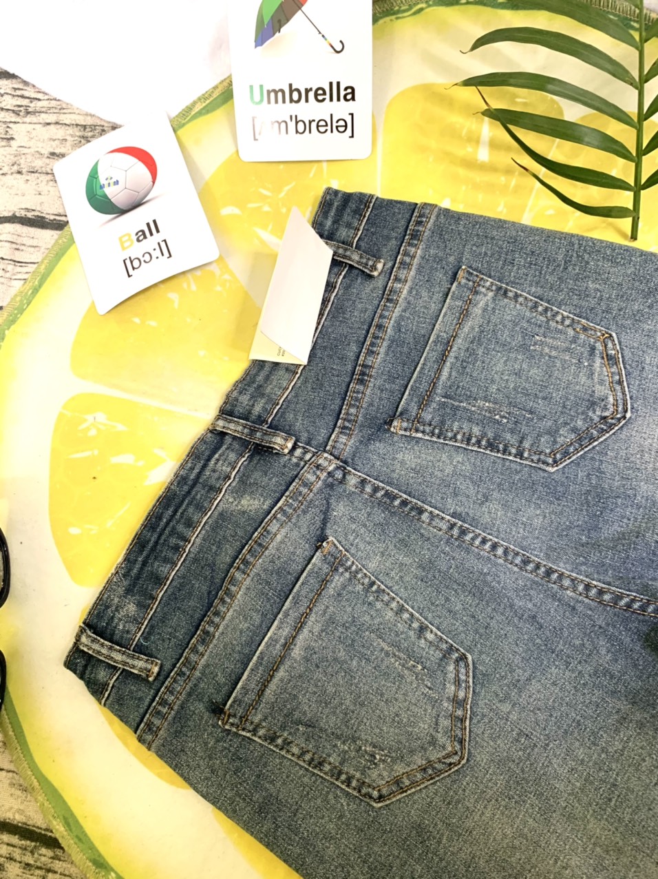 Quần jeans xanh bạc màu lai lật tua rua