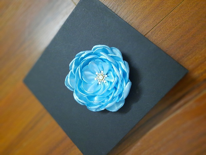 Bông hoa cài áo màu xanh, chất liệu mềm mịn