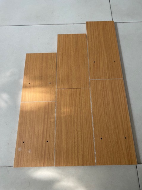 Kệ sách nhỏ hơn so với mô tả, cao 30 cm, dài tối đa 55 cm, rộng 13 cm.
Trong ảnh là hình các miếng gỗ khi so với gạch nhà, viên gạch 60 cm.