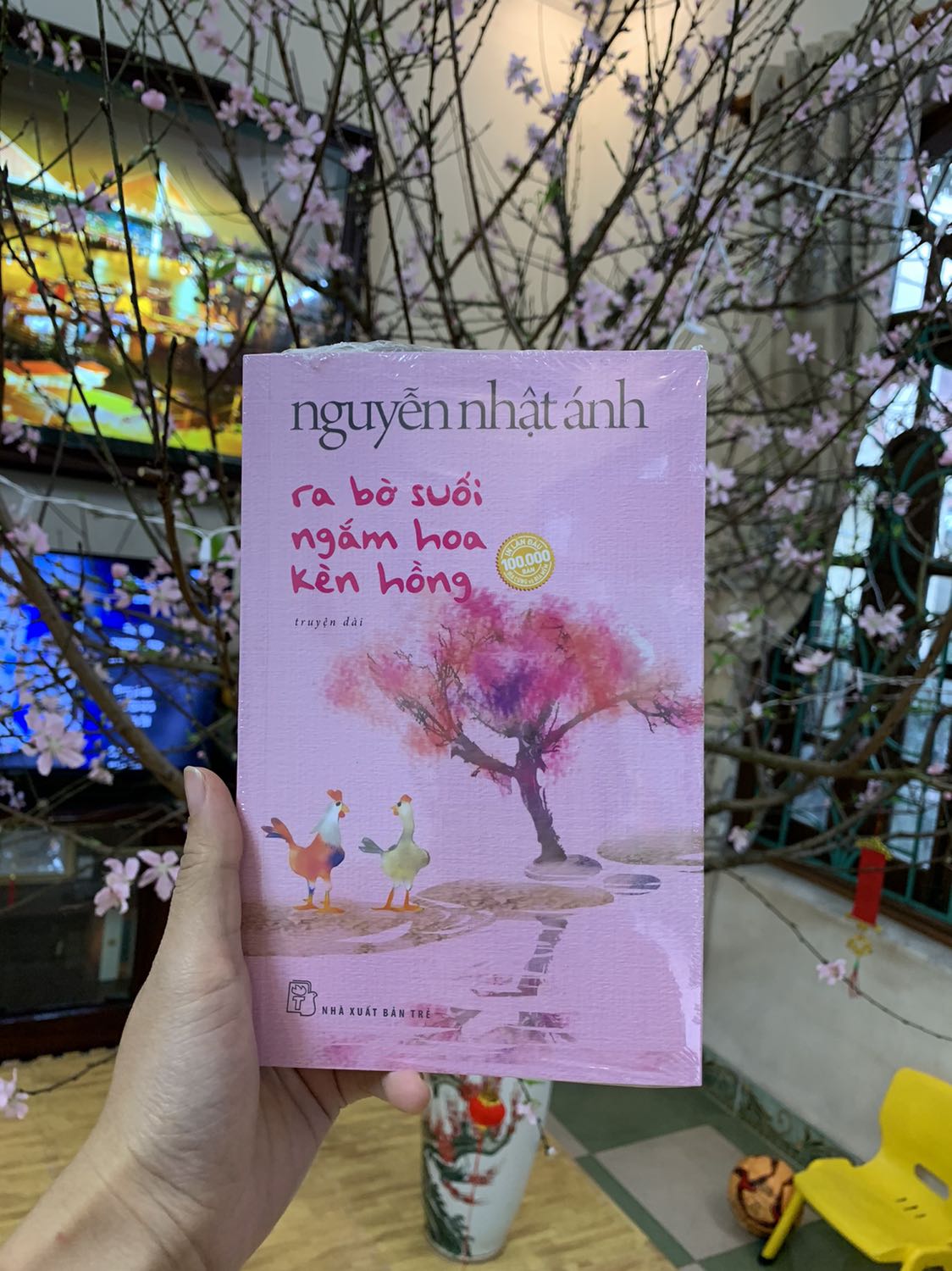 Mình mua từ trc Tết, Tiki hẹn giao 8/2 dương mà hên quá ngày 27 âm đã giao.
Mùi sách thơm phức, cuốn sách tuyệt đẹp, bookmark xịn xò và quan trọng hơn cả là câu chuyện nhân văn vô cùng của bác Ánh.
Ngòi bút viết về nỗi buồn đang tìm đến đào hang và làm tổ trong lòng cô gà con, về nỗi đau để lại vết xước trong lòng cô, về bông hoa đang nở rộ trong lòng .... bút lực và ngôn ngữ của bác Ánh mới tuyệt vời làm sao.
Vừa đọc vừa trầm trồ về những từ ngữ đắt giá, về khả năng diễn tả tâm lý, hay khả năng định nghĩ lại vài từ (như 'đời tư' hay nhiều từ khác).
Và hơn cả là mạch truyện làm người ta ồ lên ở phút cuối.
Hoá ra, ra bờ suối ngắm cây kèn hồng không phải hẳn là ngắm cây kèn hồng.
Hoá ra dưới cây kèn hồng không chỉ là câu chuyện của hai con gà đã kịp lớn tương đương nhau.
Dưới cây kèn hồng, bên bờ suối, còn là 'kỷ niệm'.
Cảm ơn bác Ánh rất nhiều.