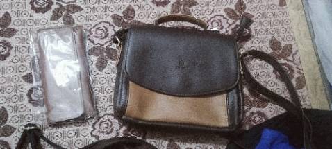 Form hơi cứng, túi trông khá to, viền thô, khoá hút ở 2 dây quai khó đóng, ngăn bên trong rộng để vừa điện thoại