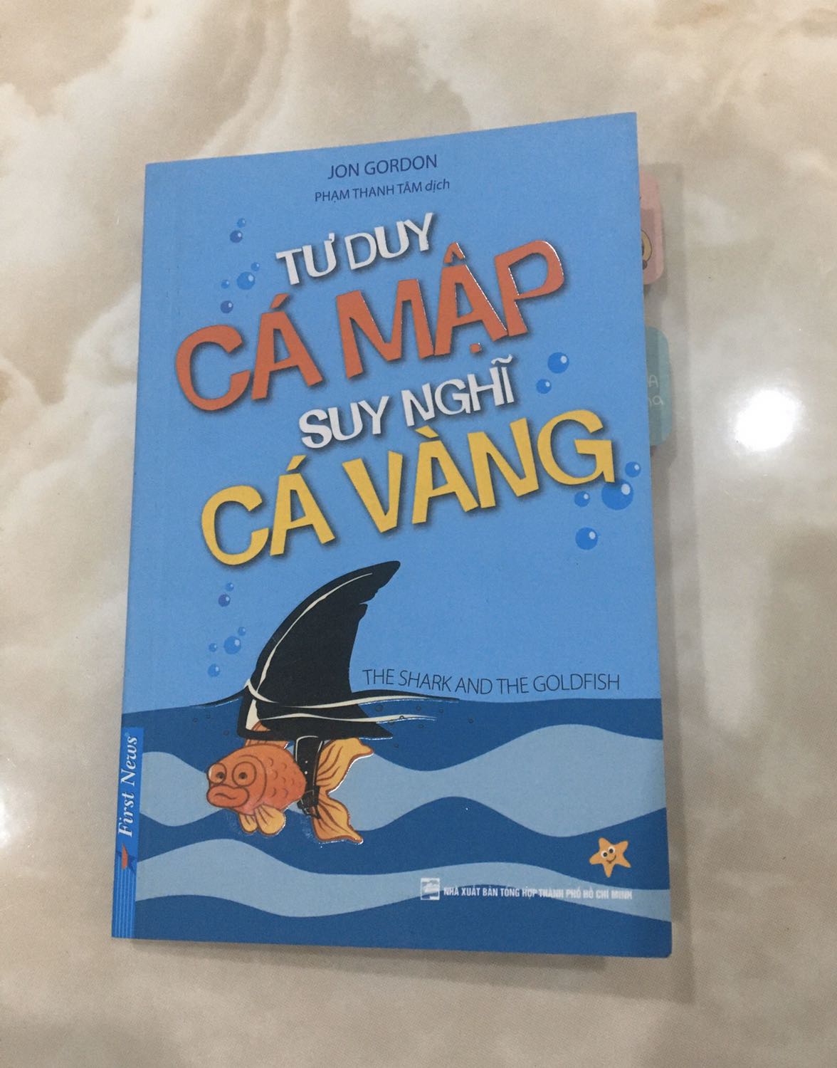 Câu chuyện về một chú cá vàng chỉ chờ được chủ cho ăn trong cái hồ bé nhỏ đột nhiên phải làm quen với biển cả rộng lớn, với những cơn sóng dữ dội và rồi được một con cá mập giảng dạy. Bỏ qua hết sự lười biếng, những lời chê bai của người khác, chú cá học đc cách thay đổi bản thân, và ngay sau đó mở một trường dạy học cho cá mập. “You can’t live a POSITIVE life with a NEGATIVE mind” - một trong những câu nói mình rất thích trong quyển sách này. 

ND của sách đơn giản chỉ là muốn khuyến khích bạn thay đổi bản thân, giúp ta thành công hơn, nd dung mà hiện tại cũng có rất nhiều sách viết về nhưng quyển sách cực kỳ nhỏ gọn, hình ảnh minh hoạ rất sinh động, truyền cảm hứng với những câu nói đáng suy ngẫm và đặc biệt có đưa ra những câu hỏi gợi ý để bạn thay đổi bản thân và chừa dòng ở cuối trang để ghi chú nx. 
Mình thấy sách rất phù hợp cho những bạn ngắn gọn đơn giản hoặc muốn kể cho con cái nghe. 

Dịch vụ giao hàng của Tiki thì khỏi phải bàn rồi.
