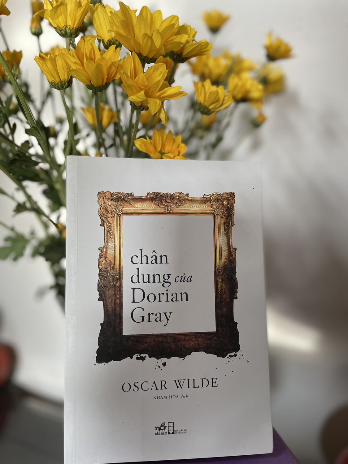 Nhẹ nhàng rồi gây cấn, êm ả rồi nổi sóng cuồn cuộn, đỉnh điểm rồi thoái trào… “Chân dung của Dorian Gray” của Oscar Wilde đã đưa người đọc đến những cung bậc khác nhau như thế.
"Chân dung của Dorian Gray" là tiểu thuyết duy nhất của Oscar Wilde và là một trong những tác phẩm có ảnh hưởng nhất trong nền văn học phương Tây. Câu chuyện kể về cuộc đời chàng quý tộc Dorian Gray mang một vẻ đẹp hoàn hảo, tuyệt mỹ tựa như đoá hồng bạch thanh khiết, không chút tì vết, chẳng chút nhuốm bụi trần. Thế rồi Dorian Gray vướng vào những mối quan hệ khiến cuộc đời của anh phải đi đến con đường hiến dâng linh hồn mình cho quỷ dữ. Đó là mối quan hệ với họa sĩ Basil Hallward - hoạ sĩ thiên tài đã đã dành tất cả tâm huyết cùng tình yêu chân thành để vẽ nên một bức chân dung cực kỳ sinh động về Dorian, người đã hết sức yêu quý, ngưỡng mộ, giữ gìn nét thuần khiết cùng vẽ đẹp sẵn có trong anh. Còn người kia là quý tộc Henry Wotton, một đại diện xuất sắc  mang thiên hướng cho tính vị kỷ, theo đuổi khoái lạc, xem cuộc sống như một vở kịch, xem con người như những diễn viên và hoàn toàn đánh mất tình yêu hay lòng trắc ẩn. Và cũng chính Herry đã góp phần đẩy Gorian vào vực thẫm của sự tha hoá, của sự suy đoài đạo đức để rồi hết lần này đến lần khác xé toạt linh hồn của chính mình, biến bản thân thành một bức tranh đẹp đẽ mà thiếu hẳn linh hồn.
Kết cục cuộc đời Dorian chắc hẳn không khó đoán nhưng kết cục của Basil, của Henry, của bức tranh, của cái đẹp, của quan điểm "Nghệ thuật vị nghệ thuật" hay "nghệ thuật vị nhân sinh" vẫn cứ làm người đọc đau đáu mãi không thôi...
24/10/21 (T.L.MH)