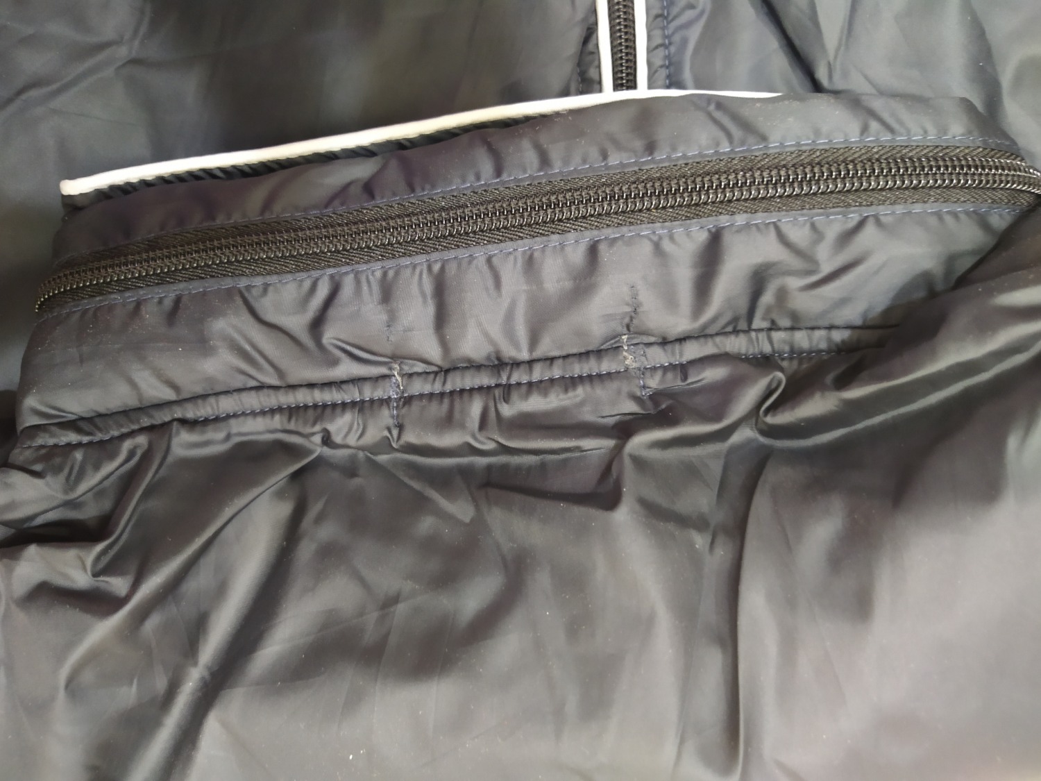 Áo này có cái mũ nè,  thấy có cái khóa kéo nhỏ trên cổ mở ra thấy có một cái mũ được gấp vào, áo đẹp, mặc dù vải dù nhưng mà bên trong có vải lót, vải có lỗ thông hơi nên cũng không nóng quá khi đi nắng