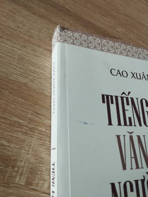 Sách trông cũ, có vết mực trên bìa, gáy sách rách và gập nếp.