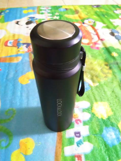 Lúc mới đặt hàng cứ nghĩ là nó sẽ nhỏ gọn thôi, không ngờ là khi cầm trên tay mới thấy nó to thật. Cầm tay nhưng chỉ giữ được 3/4 bình, được cái có dây nên cuốn vào ngón tay  cũng khá chắc chắn.

Màu đen sơn này dạng hơi đục và có vẻ là sẽ hơi dễ xước nếu để va chạm với các vật sắc nhọn và miếng kim loại giữ dây treo. Dùng nên giữ gìn thì sẽ bền đẹp dài lâu.

Chất lượng giữ nhiệt thì cũng khá ổn. Mình để qua đêm thì tối hôm trước đang là nóng, tới sáng hôm sau thì nước chỉ còn hơi ấm. Nói chung là hiệu quả sẽ trong khoảng trên dưới 10 tiếng.