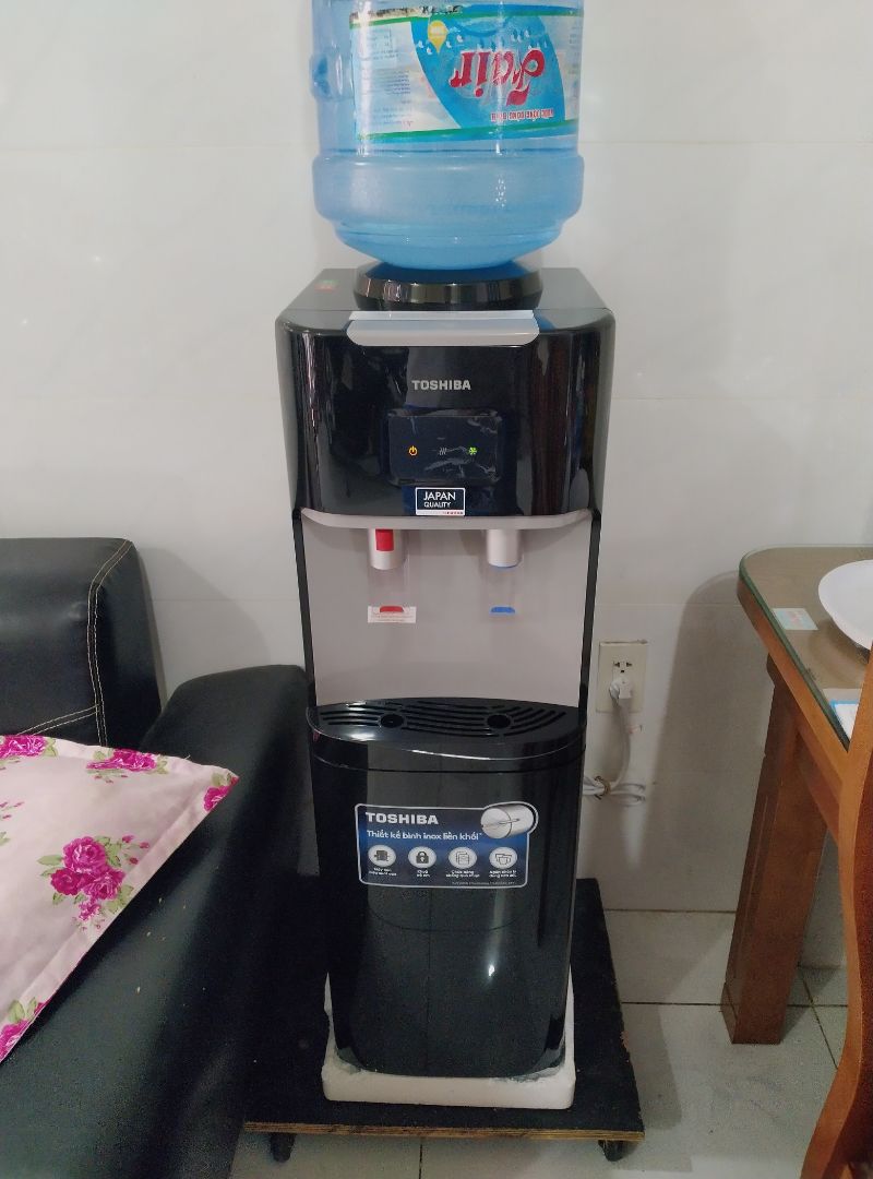 Đặt sáng hôm nay, Tiki sáng hôm sau giao ngay dù là ngoại thành. Máy mới còn niêm phong, mẫu mã đẹp, sang, phụ kiện giấy giờ đầy đủ.
Cho những ai mới lần đầu dùng cây nóng lạnh như mình (hướng dẫn mình đọc từ tờ giấy hãng kèm theo). Setup máy ở chỗ thoáng mát. Trước khi cắm nguồn, phải nối dây max (dây tiếp đất). Lắp bình nước, đợi nước lấp đầy bình nóng và bình lạnh ( lúc chổng bình vào nó sẽ ọc bọt khí, hết bọt khí là chăm đầy ). Lấy ly nước mở thử coi 2 vòi ra nước chưa (riêng vòi nóng có nút khoá an toàn phải vừa ấn nút vừa đẩy vòi nước mới chảy ra) Đợt nước đầu này sẽ có mùi nhựa do mới nên sẵn bỏ luôn. Khi đảm nước đầy đủ thì mới cắm điện và bật công tắc nóng, bật công tắc lạnh bên hông lên. Bạn chịu khó chờ nó làm nóng 15p, còn lạnh tầm 2 tiếng chưa tới. Độ nóng phù hợp uống trà cà phê ăn mì, còn lạnh thì tạm thôi, cỡ ngăn mát tủ lạnh chứ không hơn. Khi làm nóng hay lạnh xong thì đèn báo mới tắt, để ngưng sử dụng và tiết kiệm điện. Máy chạy đầm êm, ưng em ngăn mát đựng đồ khá tiện dụng!